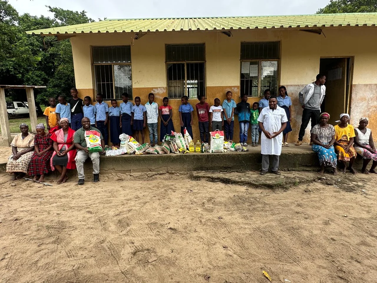 Smiling schoolchildren holding books they received through a school support programme